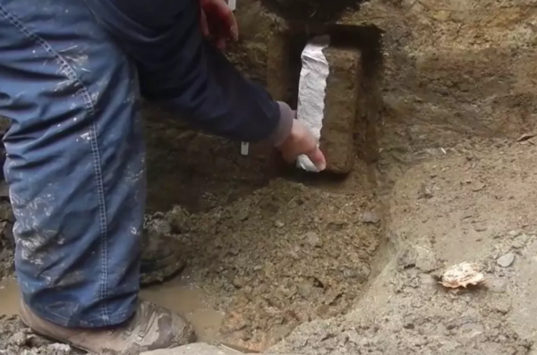 Man working in mud at excavation site